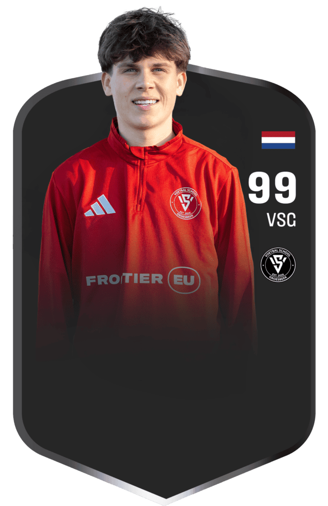 Jonge voetballer in Groesbeek tijdens training, gekleed in rood teamshirt met clublogo, klaar voor een wedstrijd of training bij Voetbalschool Groesbeek.