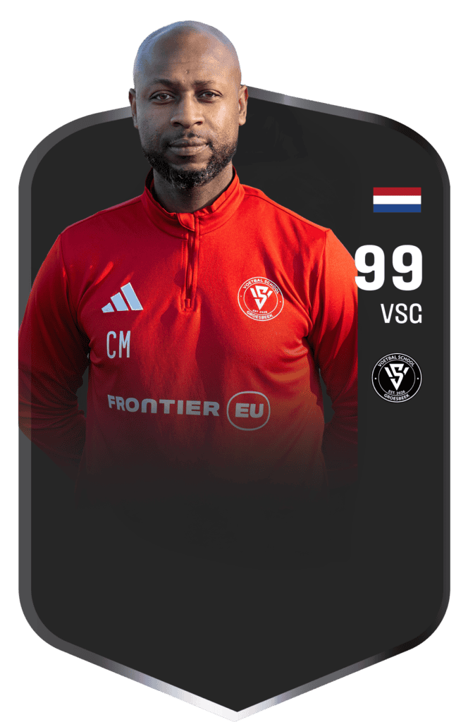 Professionele voetballer in rood trainingspak met clublogo, nummer 99, en Nederlandse vlag, promotie van Voetbalschool Groesbeek voor jonge voetbaltalenten.