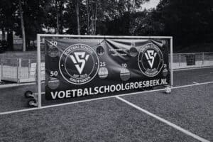 Voetbaldoel met logo en website van Voetbalschool Groesbeek op een sportveld, geschikt voor kinderfeestjes en voetbaltrainingen.