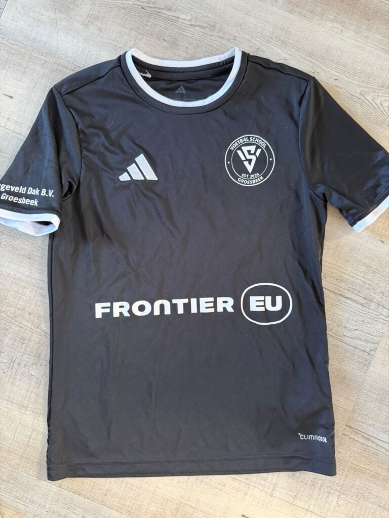Voetbalkleding met logo van Groesbeekse voetbalclub en Adidas merk, geschikt voor sportieve activiteiten.